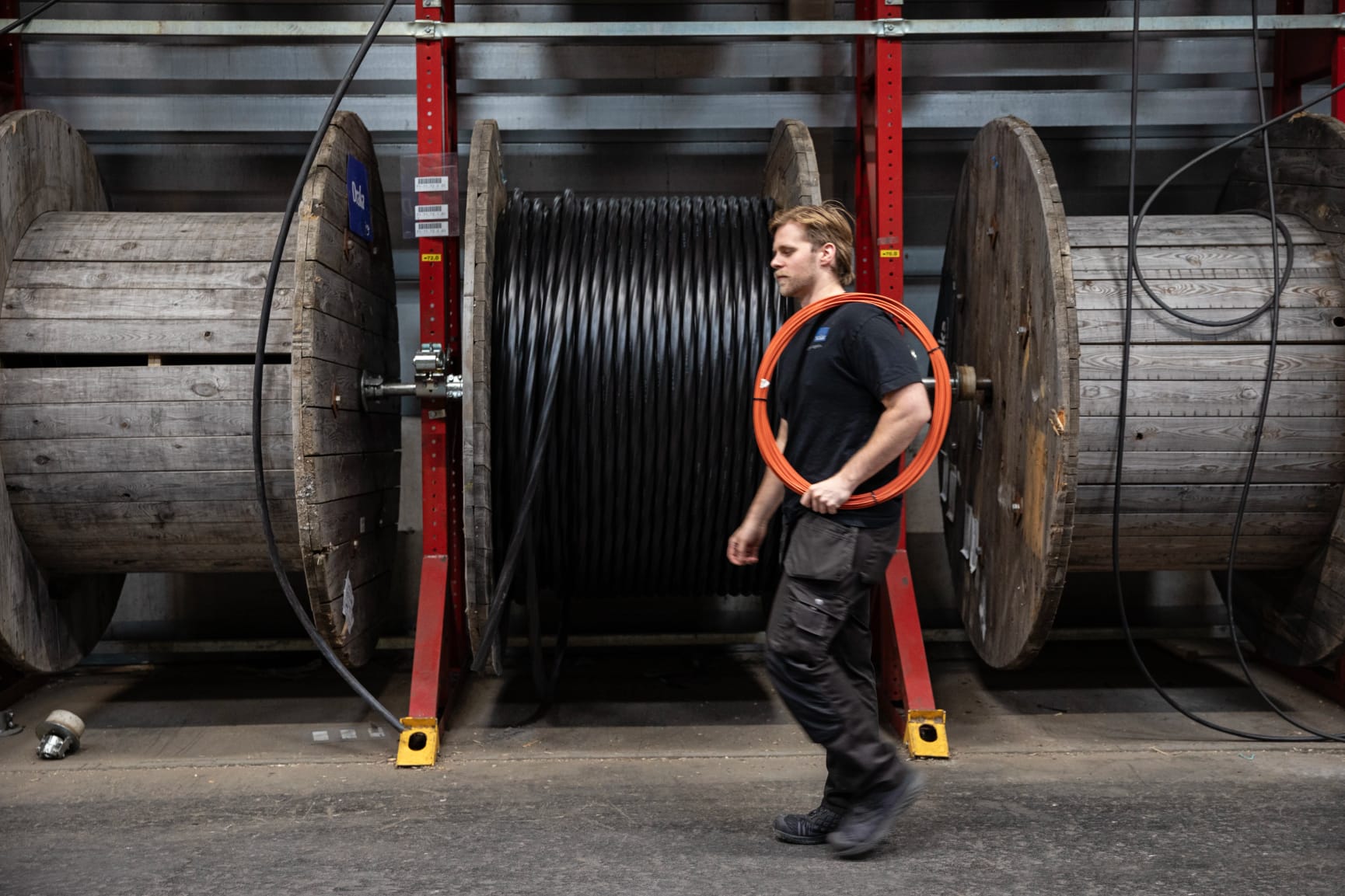 Man walking in front of large cables in warehouse
