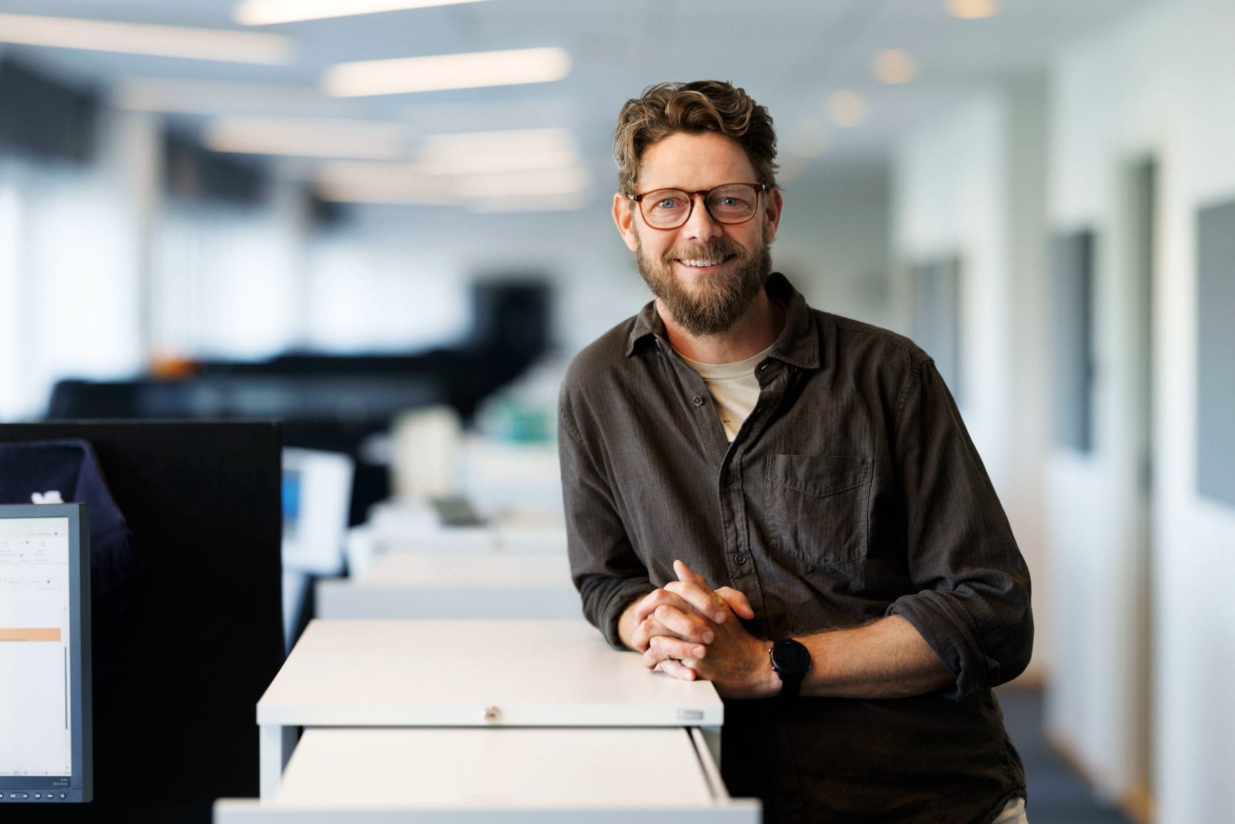 Man in office looking into camera smiling